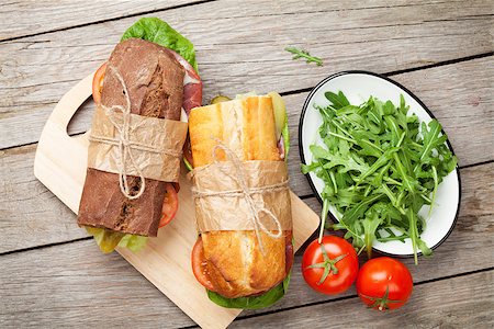simsearch:400-07099478,k - Two sandwiches with salad, ham, cheese and tomatoes on cutting board Stock Photo - Budget Royalty-Free & Subscription, Code: 400-08283587
