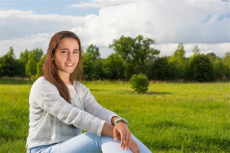 Beautiful teenager sitting on the grass at the park Stock Photo - Budget Royalty-Free & Subscription, Code: 400-08283943