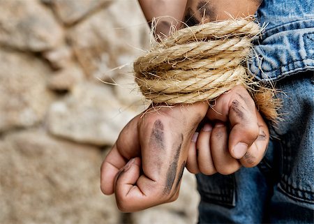 Dirty prisoner arms behind back bound with rope Stock Photo - Budget Royalty-Free & Subscription, Code: 400-08294001