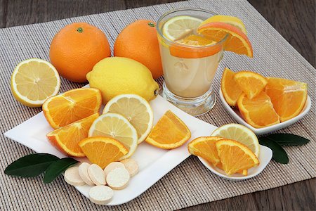 simsearch:400-08618279,k - Cold and flu health remedy drink with orange and lemon fruit and vitamin c tablets on bamboo over oak background. Photographie de stock - Aubaine LD & Abonnement, Code: 400-08294085