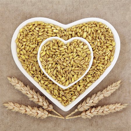 simsearch:400-08429907,k - Kamut khorasan wheat grain health food in heart shaped porcelain dishes with sheaths over brown grunge paper background. Fotografie stock - Microstock e Abbonamento, Codice: 400-08294097