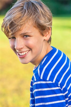 Young happy laughing male boy teenager blond child outside in summer sunshine wearing a blue striped t-shirt Stock Photo - Budget Royalty-Free & Subscription, Code: 400-08294700