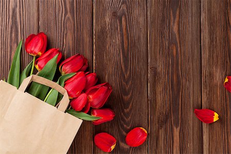 simsearch:400-08036453,k - Red tulips bouquet in paper bag over wooden table background with copy space Stock Photo - Budget Royalty-Free & Subscription, Code: 400-08294940