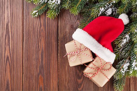 pinecones and ribbons - Christmas tree branch and santa hat with gift boxes on wooden table. Top view with copy space Stock Photo - Budget Royalty-Free & Subscription, Code: 400-08295034