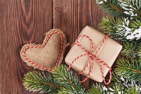 Christmas tree branch with snow, gift box and heart toy on wooden table. Top view Stock Photo - Budget Royalty-Free & Subscription, Code: 400-08295037