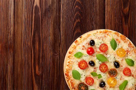 simsearch:400-08291219,k - Italian pizza with cheese, tomatoes, olives and basil on wooden table. Top view with copy space Stock Photo - Budget Royalty-Free & Subscription, Code: 400-08295734