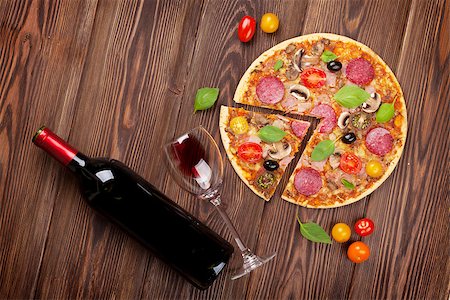 simsearch:400-08960199,k - Italian pizza with pepperoni, tomatoes, olives, basil and red wine on wooden table. Top view Stock Photo - Budget Royalty-Free & Subscription, Code: 400-08295736