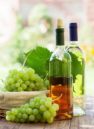 simsearch:400-08791429,k - White wine bottles, vine and bunch of grapes on garden table Stockbilder - Microstock & Abonnement, Bildnummer: 400-08295799