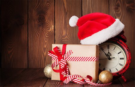 Christmas gift box, alarm clock and santa hat. View with copy space Foto de stock - Super Valor sin royalties y Suscripción, Código: 400-08295820