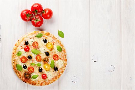 simsearch:400-08960199,k - Italian pizza with cheese, tomatoes, olives and basil on wooden table. Top view with copy space Stock Photo - Budget Royalty-Free & Subscription, Code: 400-08296751