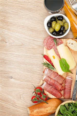 simsearch:400-07481826,k - Red wine with cheese, olives, tomatoes, prosciutto, bread and spices. Over wooden table background. View from above with copy space Stock Photo - Budget Royalty-Free & Subscription, Code: 400-08296806