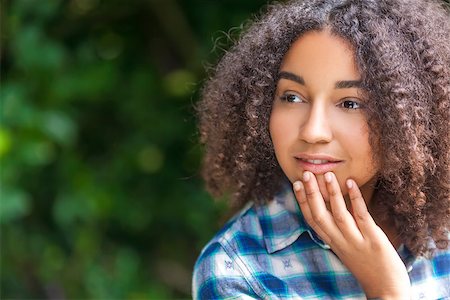 simsearch:400-04068097,k - Outdoor portrait of beautiful happy mixed race African American girl teenager female child smiling and looking thoughtful Stockbilder - Microstock & Abonnement, Bildnummer: 400-08297653