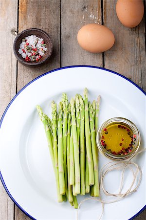 Fresh asparagus, olive oil and eggs on a white enamel plate. Photographie de stock - Aubaine LD & Abonnement, Code: 400-08297701