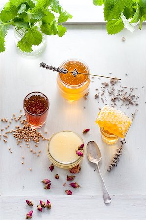 Honey variety with bee's comb in a glass jars with flowers and fresh herbs. Photographie de stock - Aubaine LD & Abonnement, Code: 400-08298751