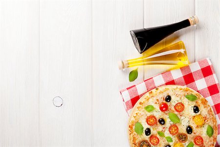 simsearch:400-08291219,k - Italian pizza with cheese, tomatoes, olives and basil on wooden table. Top view with copy space Stock Photo - Budget Royalty-Free & Subscription, Code: 400-08298816