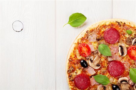 simsearch:400-08960199,k - Italian pizza with pepperoni, tomatoes, olives and basil on wooden table. Top view with copy space Stock Photo - Budget Royalty-Free & Subscription, Code: 400-08298817
