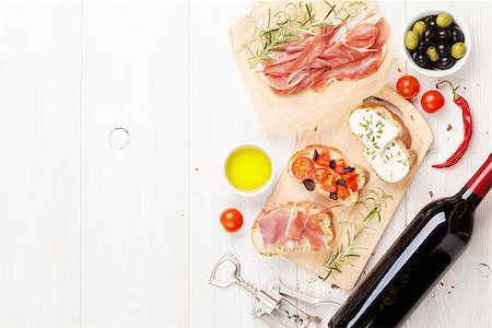 simsearch:824-02888261,k - Bruschetta with cheese, tomatoes and prosciutto on cutting board. Top view with copy space Stock Photo - Budget Royalty-Free & Subscription, Code: 400-08298825