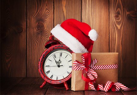 Christmas gift box, alarm clock and santa hat. View with copy space Foto de stock - Super Valor sin royalties y Suscripción, Código: 400-08298887