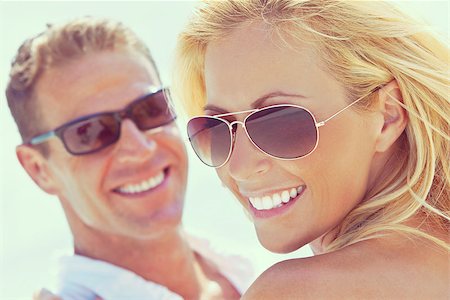simsearch:400-04310598,k - Instagram style photograph of happy and attractive man and woman couple wearing sunglasses and smiling in sunshine at the beach Stock Photo - Budget Royalty-Free & Subscription, Code: 400-08299092
