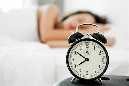 simsearch:400-08299475,k - Beautiful young woman waking up with the alarm clock Stock Photo - Budget Royalty-Free & Subscription, Code: 400-08299472