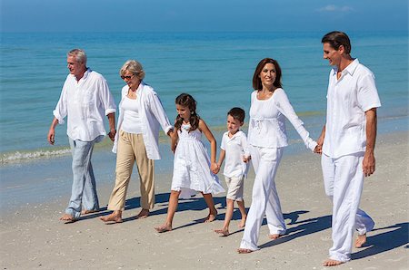 A happy family of mother, father, grandparents and two children, son and daughter, walking holding hands and having fun in the sand on a sunny beach Stock Photo - Budget Royalty-Free & Subscription, Code: 400-08299605