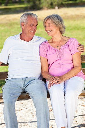 Happy senior man and woman couple sitting together on a park bench outside in sunshine Stock Photo - Budget Royalty-Free & Subscription, Code: 400-08299600