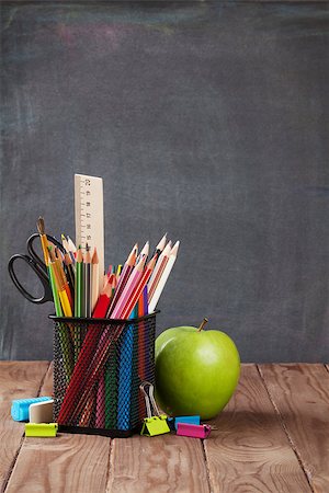 simsearch:400-08288625,k - School and office supplies and apple on classroom table in front of blackboard. View with copy space Foto de stock - Royalty-Free Super Valor e Assinatura, Número: 400-08299666