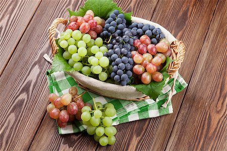 Bunch of red, purple and white grapes in basket on wooden table background Stock Photo - Budget Royalty-Free & Subscription, Code: 400-08299667