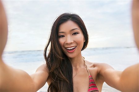 simsearch:400-08291180,k - Asian young woman or girl in bikini, taking vacation selfie photograph at the beach Foto de stock - Royalty-Free Super Valor e Assinatura, Número: 400-08291180