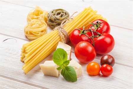 simsearch:400-08890289,k - Italian food cooking ingredients. Pasta, tomatoes, basil on wooden table Foto de stock - Royalty-Free Super Valor e Assinatura, Número: 400-08291194