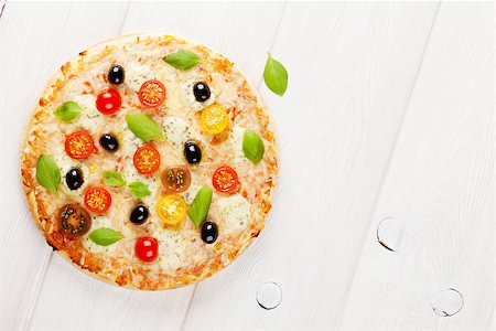 simsearch:400-08291219,k - Italian pizza with cheese, tomatoes, olives and basil on wooden table. Top view with copy space Stock Photo - Budget Royalty-Free & Subscription, Code: 400-08291198
