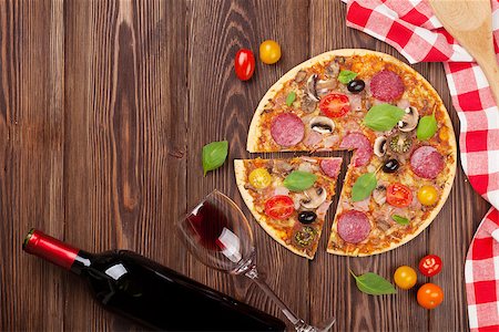 simsearch:400-08960199,k - Italian pizza with pepperoni, tomatoes, olives, basil and red wine on wooden table. Top view with copy space Stock Photo - Budget Royalty-Free & Subscription, Code: 400-08291200
