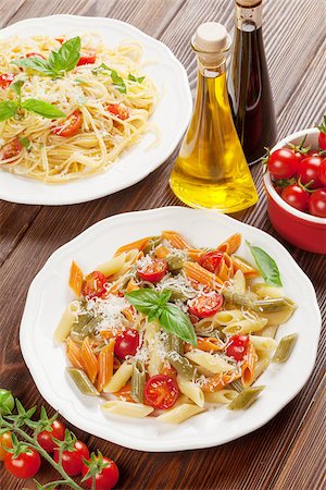 pasta dish with olives on white background - Spaghetti and penne pasta with tomatoes and basil on wooden table Stock Photo - Budget Royalty-Free & Subscription, Code: 400-08291315