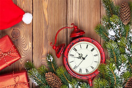 Christmas wooden background with clock, snow fir tree, gift boxes and santa hat Stock Photo - Budget Royalty-Free & Subscription, Code: 400-08291424