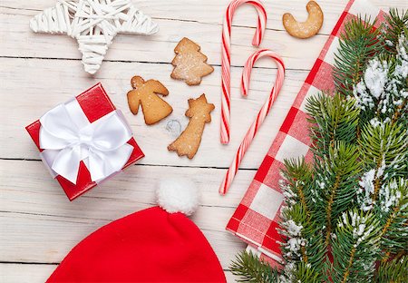 simsearch:400-04805110,k - Christmas gift box, santa hat, gingerbread cookies and snow fir tree. View from above over white wooden table background Stock Photo - Budget Royalty-Free & Subscription, Code: 400-08291436