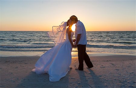 simsearch:400-04923739,k - A married couple, bride and groom, kissing at sunset or sunrise on a beautiful tropical beach Foto de stock - Super Valor sin royalties y Suscripción, Código: 400-08291851