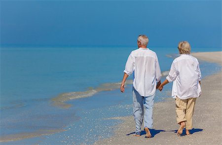 simsearch:400-05711437,k - Senior man and woman couple holding hands walking on a deserted beach Stock Photo - Budget Royalty-Free & Subscription, Code: 400-08292393