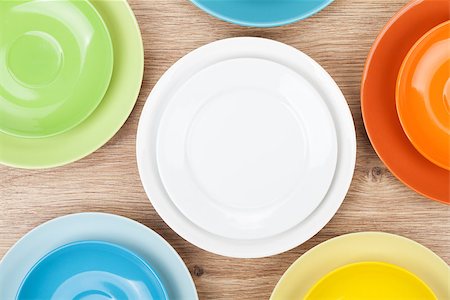 simsearch:400-07331603,k - Colorful plates and saucers over wooden table background. View from above Foto de stock - Super Valor sin royalties y Suscripción, Código: 400-08293305