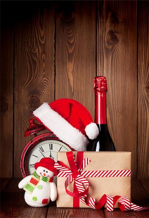 Christmas gift box, alarm clock with santa hat and champagne bottle Photographie de stock - Aubaine LD & Abonnement, Code: 400-08293370