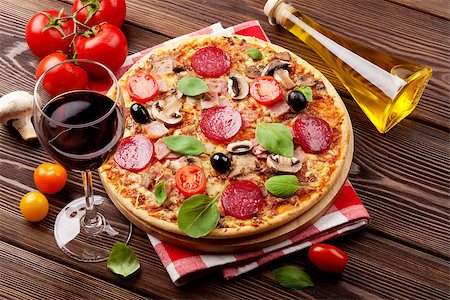 simsearch:400-08291219,k - Italian pizza with pepperoni, tomatoes, olives, basil and red wine on wooden table. Top view Stock Photo - Budget Royalty-Free & Subscription, Code: 400-08293415