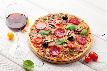 simsearch:400-08960199,k - Italian pizza with pepperoni, tomatoes, olives, basil and red wine on wooden table. Top view Stock Photo - Budget Royalty-Free & Subscription, Code: 400-08293416
