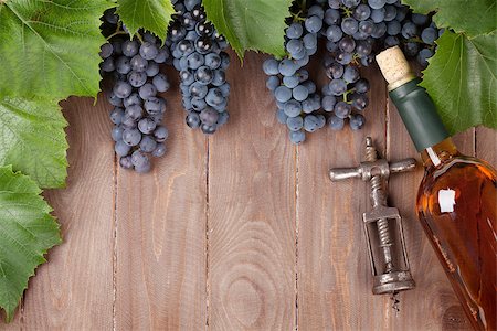 Red grape, wine bottle and vintage corkscrew on wooden table. Top view with copy space Stock Photo - Budget Royalty-Free & Subscription, Code: 400-08293479