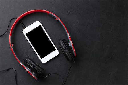 simsearch:400-08625784,k - Headphones and smartphone on black leather desk table. Top view with copy space Photographie de stock - Aubaine LD & Abonnement, Code: 400-08293510