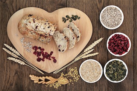 simsearch:640-01354973,k - Cranberry seed bread on heart shaped board with wheat and sheaths, sunflower and pumpkin seeds, oatmeal  and dried cranberries over old oak background. Foto de stock - Royalty-Free Super Valor e Assinatura, Número: 400-08293907