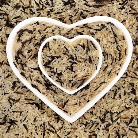 simsearch:400-08429907,k - Long grain wild rice in heart shaped porcelain dishes forming an abstract background. Fotografie stock - Microstock e Abbonamento, Codice: 400-08293945