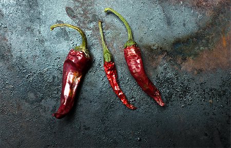 dark surface - dried red chili peppers on dark background Photographie de stock - Aubaine LD & Abonnement, Code: 400-08300263