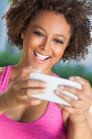 simsearch:400-08291180,k - African American mixed race young woman or girl taking selfie photograph using smartphone or cell phone Foto de stock - Royalty-Free Super Valor e Assinatura, Número: 400-08300637