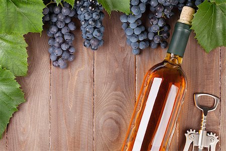 Red grape, wine bottle and corkscrew on wooden table. Top view with copy space Stock Photo - Budget Royalty-Free & Subscription, Code: 400-08300734
