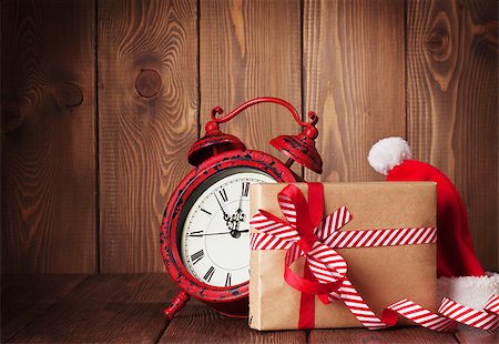 Christmas gift box, alarm clock and santa hat. View with copy space Foto de stock - Super Valor sin royalties y Suscripción, Código: 400-08300766