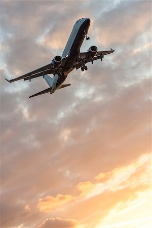 A modern commercial airplane or airliner flying at sunrise or sunset Stock Photo - Budget Royalty-Free & Subscription, Code: 400-08301476